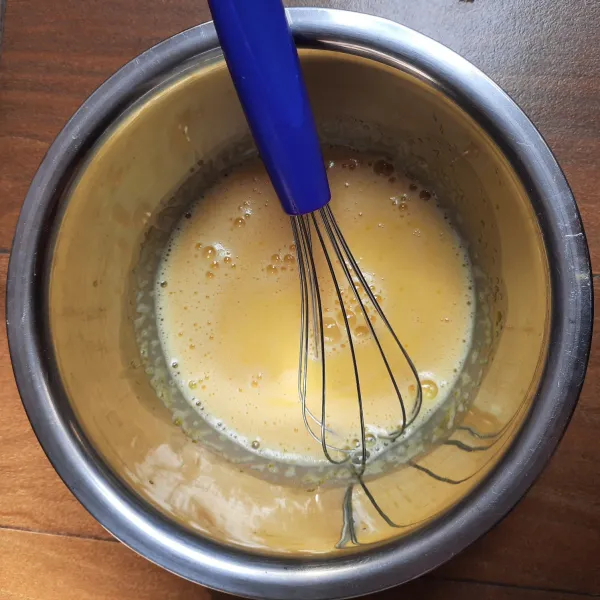 Bahan 1: masukkan kuning telur dan gula pasir, kocok rata dengan whisk. Tuang susu cair dan minyak. Aduk rata dengan whisk.