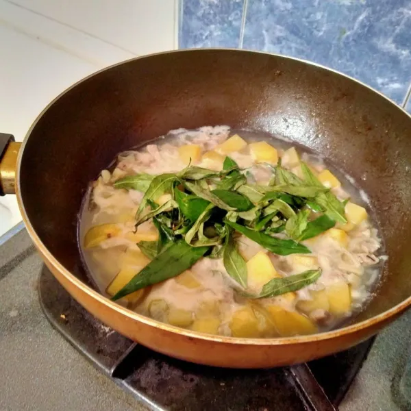 Kemudian masukkan kentang dan daun laksa. Tambahkan air secukupnya, agar tidak kering.