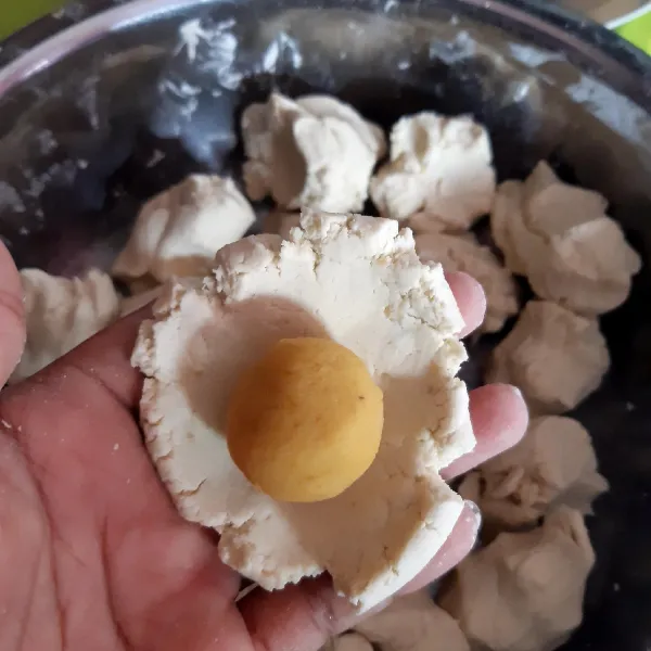 Bagi juga adonan kulit menjadi 21 buah. Ambil 1 bagian kemudian pipihkan. Beri isian, rapatkan dan bulatkan.