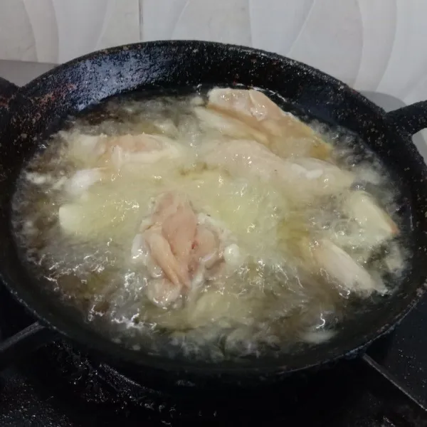 Goreng Ayam bersama bawang putih geprek hingga kuning kecoklatan dan sajikan.