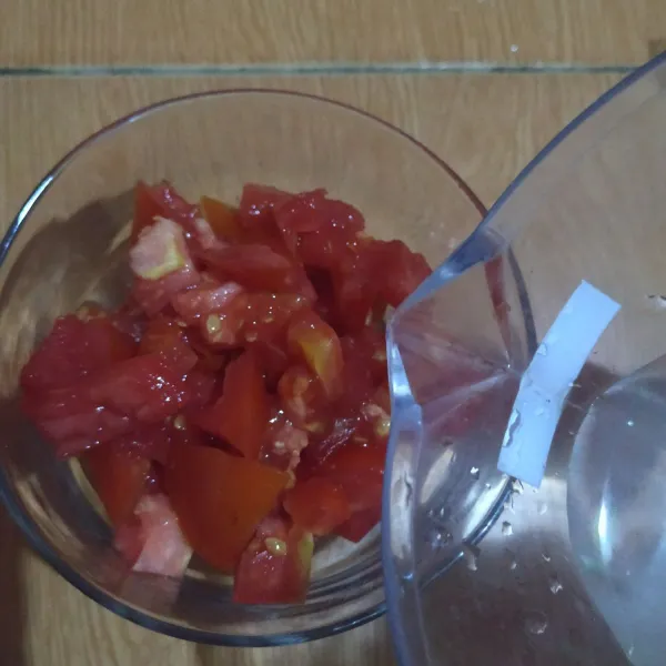 Masukkan ke dlm gelas saji, beri air dingin secukupnya, lalu tekan² tomatnya dengan sendok.