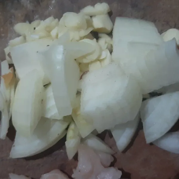 Cincang bawang putih dan iris tipis bawang bombay.