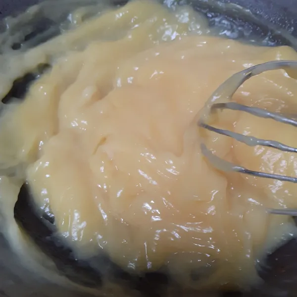 Masukkan campuran tepung ke dalam campuran susu dan aduk sampai kental. Matikan api lalu masukan margarin, kuning telur satu per satu, dan vanili. Aduk sampai rata