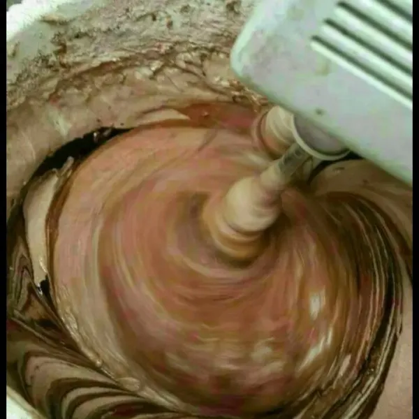 Kecilkan mixer masukan terigu, singkong parut, coklat bubuk dan lelehan margarin dan dcc secara bertahap lalu matikan mixer.