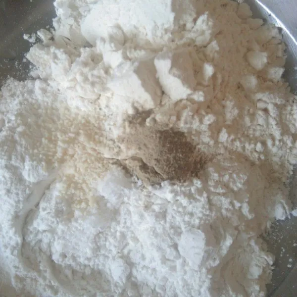 Siapkan wadah berisi tepung terigu, tepung beras, garam, merica bubuk, dan kaldu jamur. Aduk rata