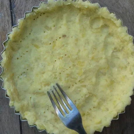 Ratakan di cetakan pie bongkar pasang yang dioles sedikit margarin. Tusuk-tusuk dengan garpu agar tidak mengembung saat dioven. Masukkan dalam oven yang sudah panas. Oven kurang lebih 10 menit, dengan suhu kurang lebih 180 derajat.