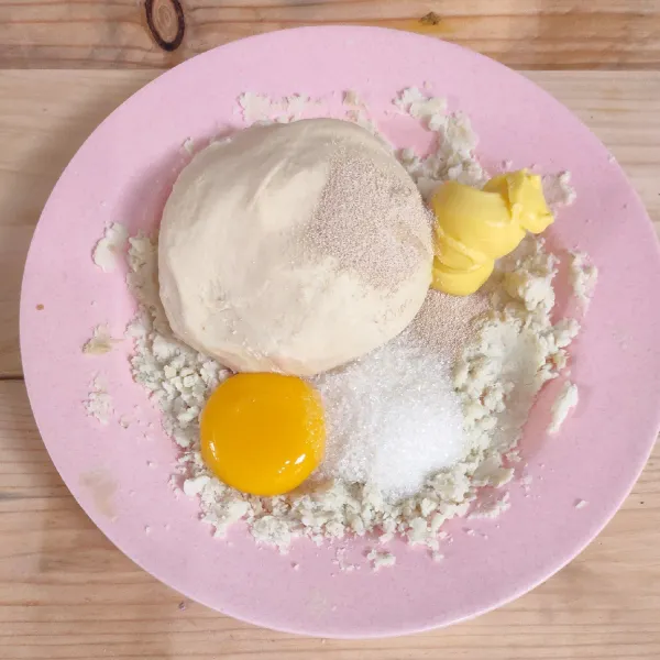 Tambahkan adonan tepung terigu, kuning telur, gula pasir, ragi instan, garam dan margarin.