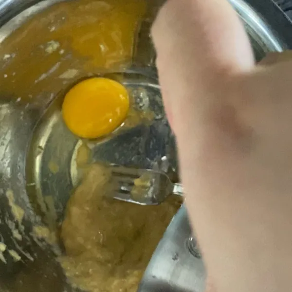 Masukkan 1 butir telur lalu aduk bersama pisang sampai menyatu.