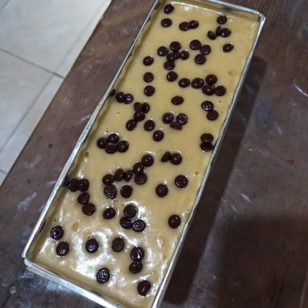 Tuang adonan dalam loyang, taburi dengan choco chips