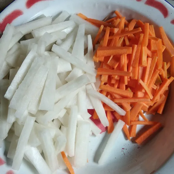Pertama cuci bersih wortel dan lobak, kupas, potong korek api lalui rendam lobak dengan 1 sdt garam + secukupnya air selama 15 menit. Tiriskan.