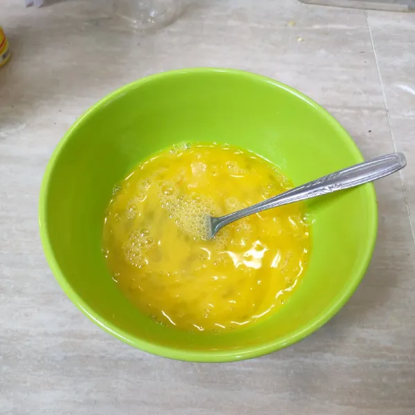 Dalam mangkuk, telur dikocok lepas.