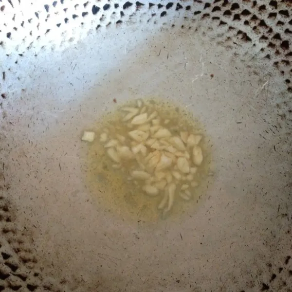 Panaskan minyak goreng, lalu tumis bawang putih hingga harum.