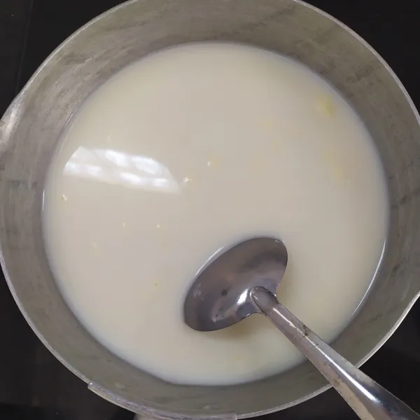 Masak bahan puding susu di atas kompor, aduk perlahan saja dengan apu kecil agar susu tidak pecah