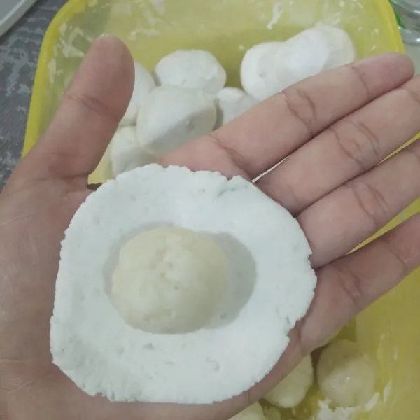 Ambil 1 adonan kulit, pipihkan di tangan. Kemudian tambahkan adonan isi. Bulatkan kembali. Lakukan sampai adonan habis.