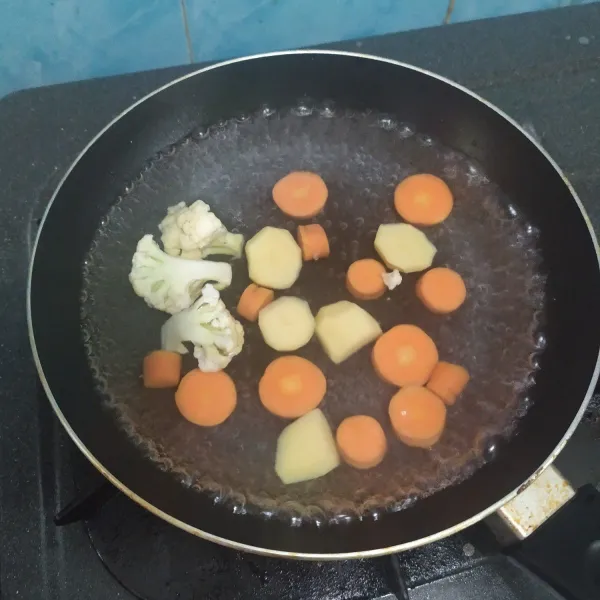 Masak wortel, kentang, dan kembang kol.