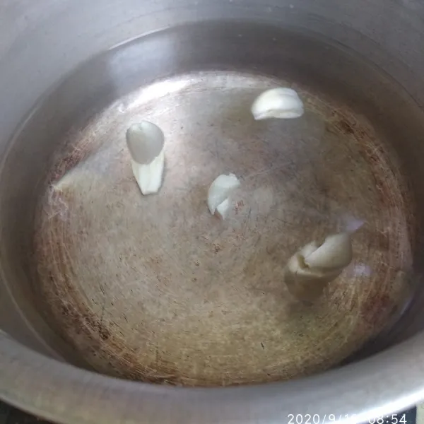 Didihkan air dan bawang putih geprek.