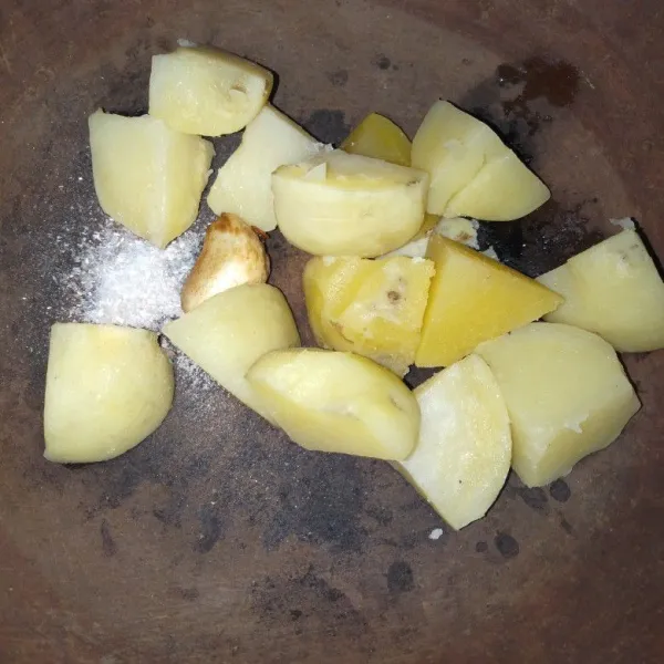 Kupas kentang. Masukkan ke dalam cobek beserta bawang putih yang sudah digoreng. Tambahkan garam dan kaldu jamur.