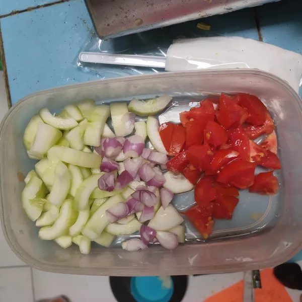 Cuci bersih lalu potong timun, buang isinya. Potong kasar tomat dan bawang merah. Sisihkan.