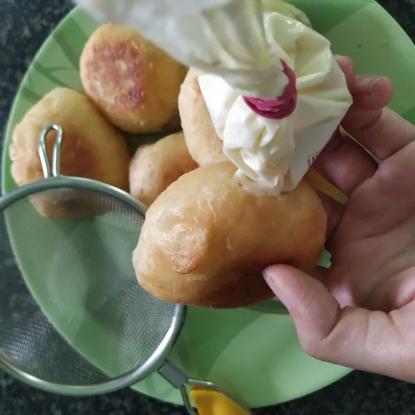 Tempatkan glaze diplastik gunting ujungnya lalu isi donatnya.