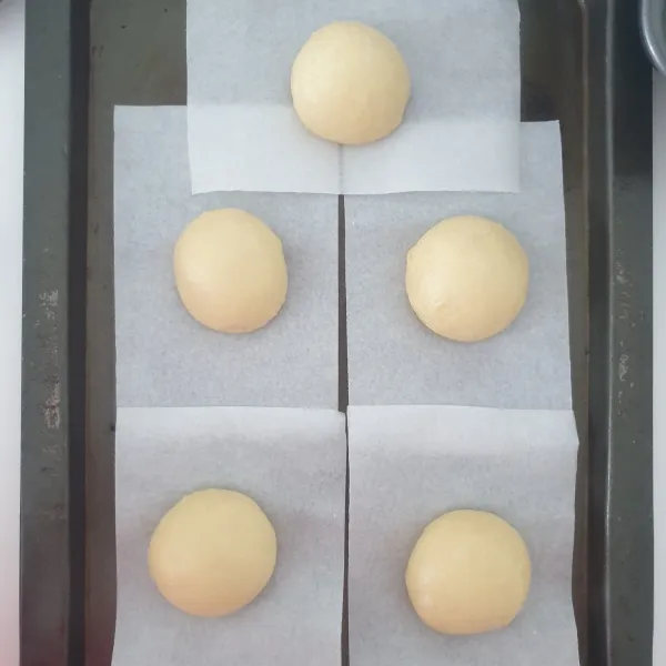 Bulatkan adonan dan letakan di atas parchment paper. Tutup dengan plastik wrap.