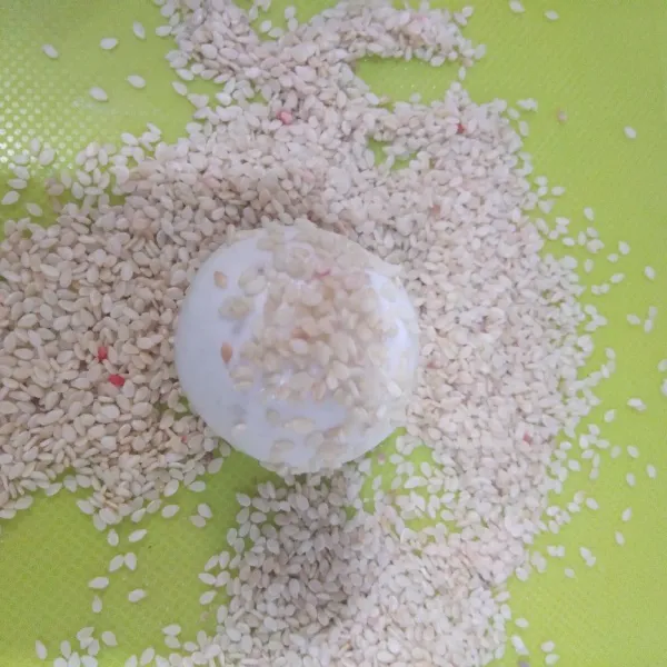 Gulingkan di atas wijen sampai permukaan rata.