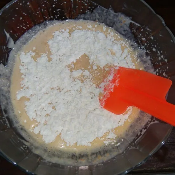 Tambahkan tepung terigu, tepung tapioka dan soda kue, aduk hingga rata.