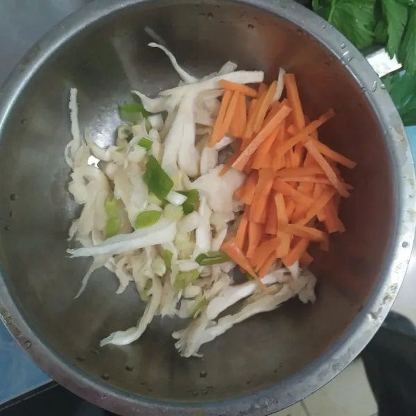 Suwir jamur tiram dan potong memanjang wortel.