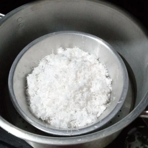 Masukkan kelapa parut dalam wadah tahan panas, beri sedikit garam lalu aduk hingga merata, kemudian kukus kurang lebih 10 menit.
