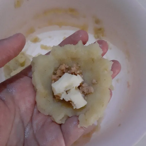Ambil sedikit adonan kentang, bentuk bulat dan pipihkan. Isi dengan isian tumisan ayam dan beri sedikit keju mozarella. Tutup adonan kentang dan bentuk bulat kembali. Sisihkan.