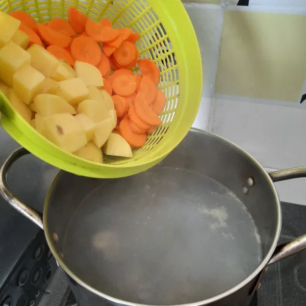 Rebus kembali ayam dalam air, bila sudah empuk masukan wortel dan kentang yang sudah dipotong-potong.