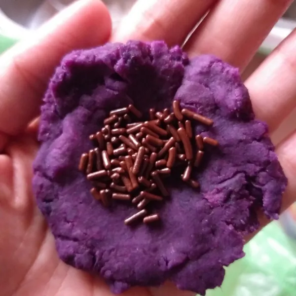 Ambil satu kepal ubi ungu, kemudian pipihkan, isi coklat ditengahnya, kemudian tutup dan bulatkan, lakukan hingga habis.