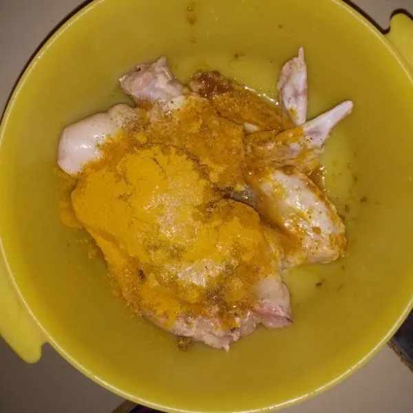 Campurkan sayap ayam, bawang putih halus, merica bubuk, kunyit bubuk, ketumbar bubuk, dan kaldu bubuk. Aduk hingga bumbu tercampur rata.