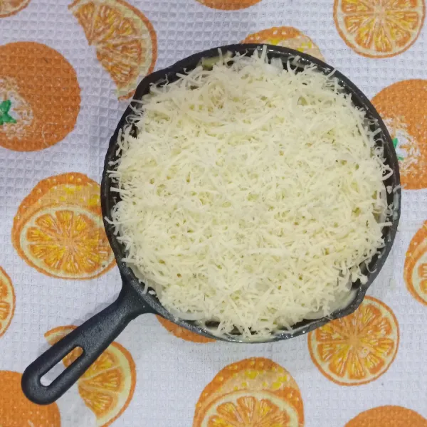 Tambahkan keju cheddar lebih banyak dibanding lapisan yang lain pada lapisan teratas dan tambahkan keju mozarella bila mau.