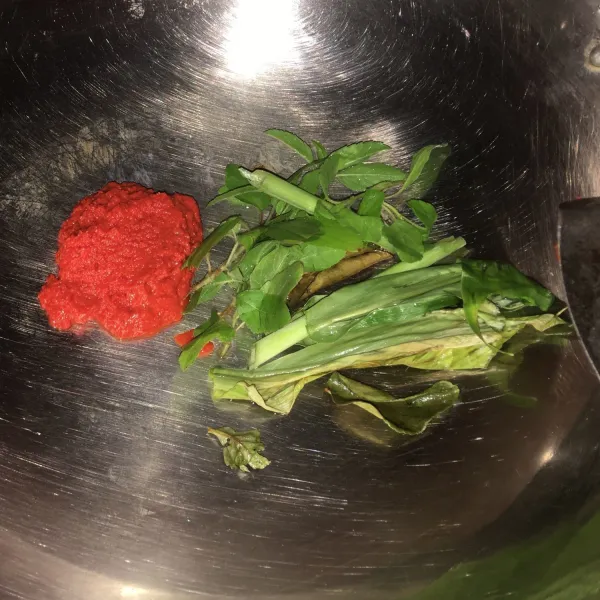 Masukkan cabai giling, daun kunyit, daun ruku-ruku, serai, dan daun jeruk