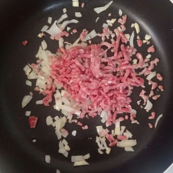 Tambahkan bawang putih dan daging cincang, masak hingga daging berubah warna.