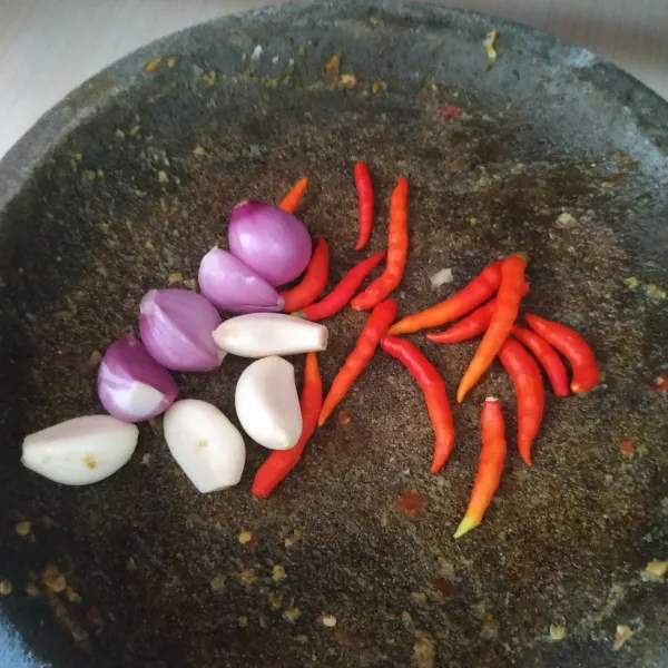 Haluskan bawang merah, bawang putih, dan cabai rawit