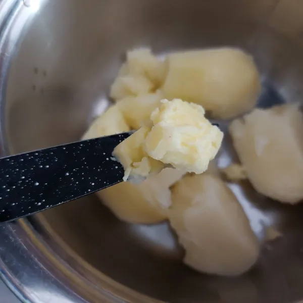 Rebus kentang hingga matang. Lalu haluskan, selagi panas campur dengan butter.