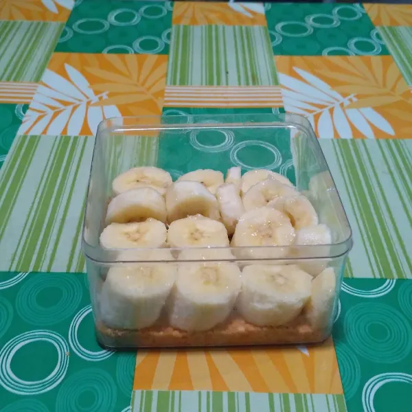 Ambil crumble. Tata potongan pisang ke dalam wadah