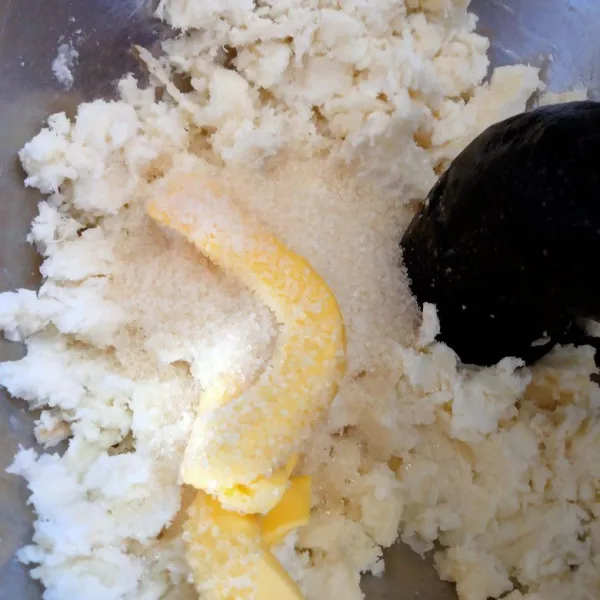 Saat masih panas, tumbuk singkong hingga halus. Tambahkan mentega dan gula pasir. Aduk rata.