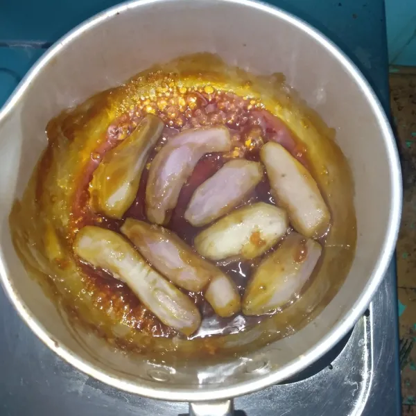 Masukkan ubi yang sudah matang ke dalam karamel, aduk hingga rata.