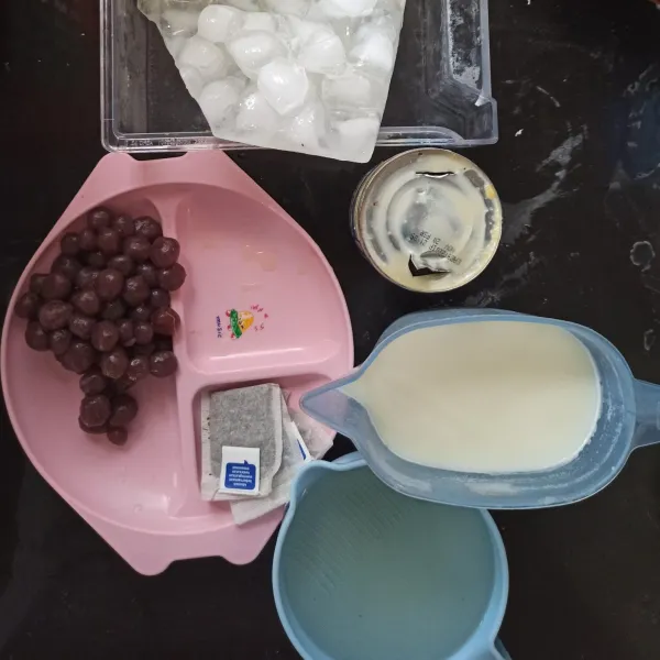 Siapkan bahan. Celupkan teh pada air hangat, setelah berubah warna campurkan pada susu cair.