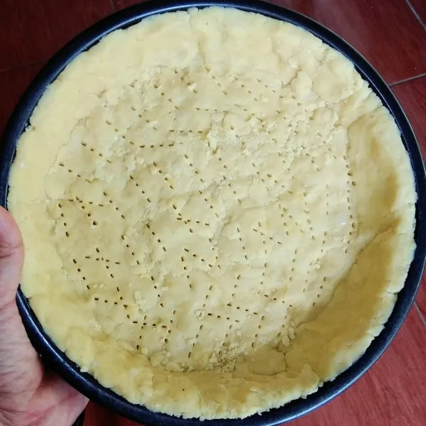Olesi teflon atau loyang pie dengan minyak. Lalu masukan adonan pie ke dalamnya. Tekan-tekan lperlahan adonan pie agar menyebar dan membentuk seperti cetakannya. Lalu tusuk-tusuk dengan garpu permukaannya.