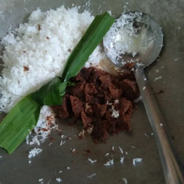 Membuat isi unti kelapa : masak kelapa parut, gula Jawa, gula pasir, dan daun pandan. Masak dengan api kecil.