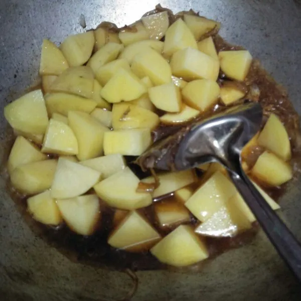 Masukkan kentang. Aduk rata dan tutup wajan. Biarkan hingga kentang empuk, bumbu meresap, dan air sedikit menyusut.