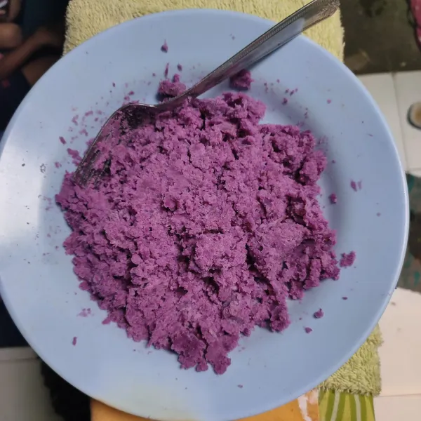 Lumatkan ubi ungu dengan bantuan garpu. Tambahkan gula putih agar ikut hancur.