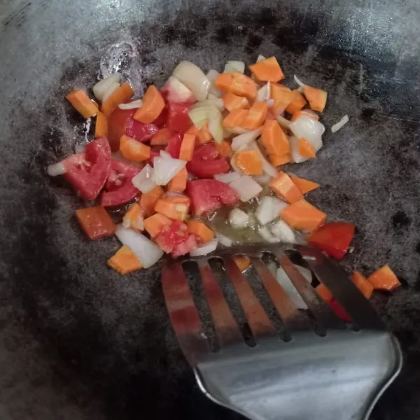 Panaskan minyak, tumis bawang bombay, wortel, dan tomat hingga layu