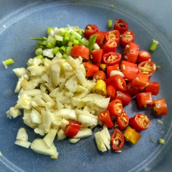 Cincang bawang putih, potong-potong cabai rawit dan daun bawang