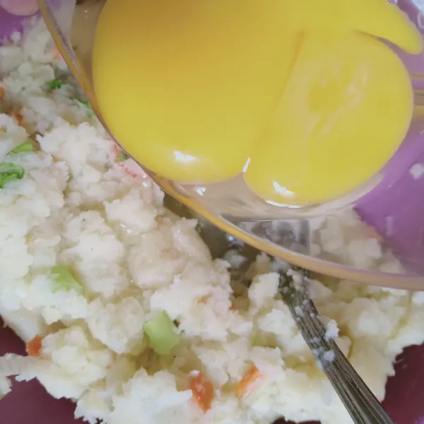Campurkan kuning telur ke dalam adonan lalu aduk lagi sampai merata