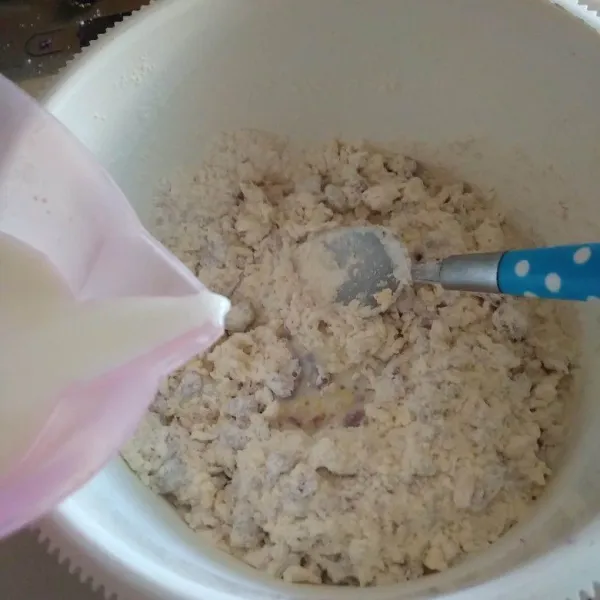 Masukkan susu cair sedikit demi sedikit lalu aduk rata.