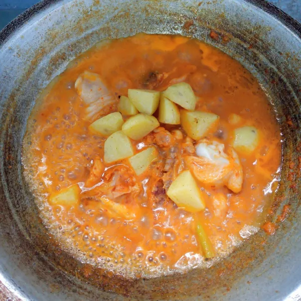 Tambahkan kentang. Aduk rata. Masak sampai mendidih dan kuah menyusut. Angkat dan sajikan.